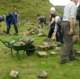 Locales en Escocia quitando las pilas de piedras montadas por turistas